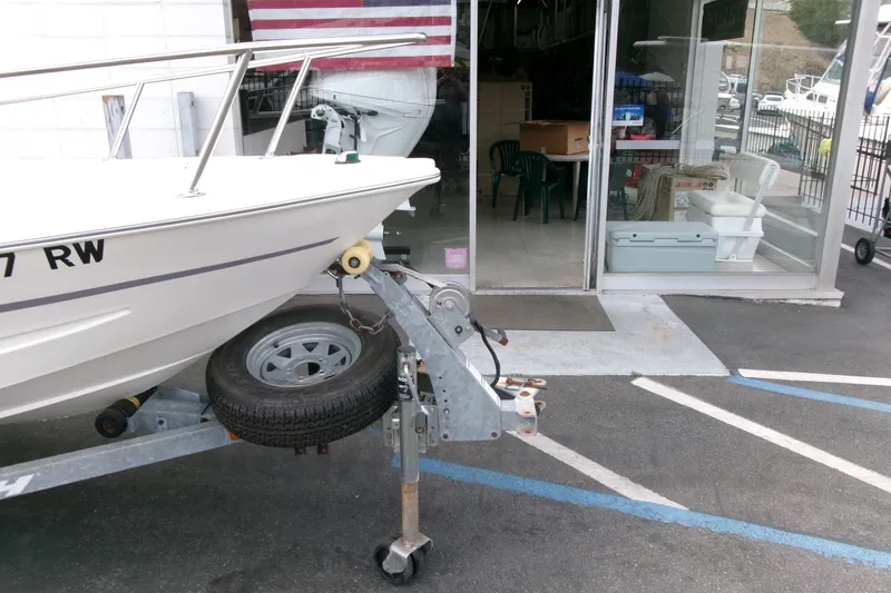 Slide: The Image of 2014 Triumph 170 CC boat on trailer outside a store with American flag. - 23