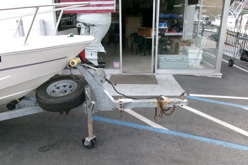 Slide: The Image of 2014 Triumph 170 CC boat on trailer, parked outside a shop with American flag. - 22