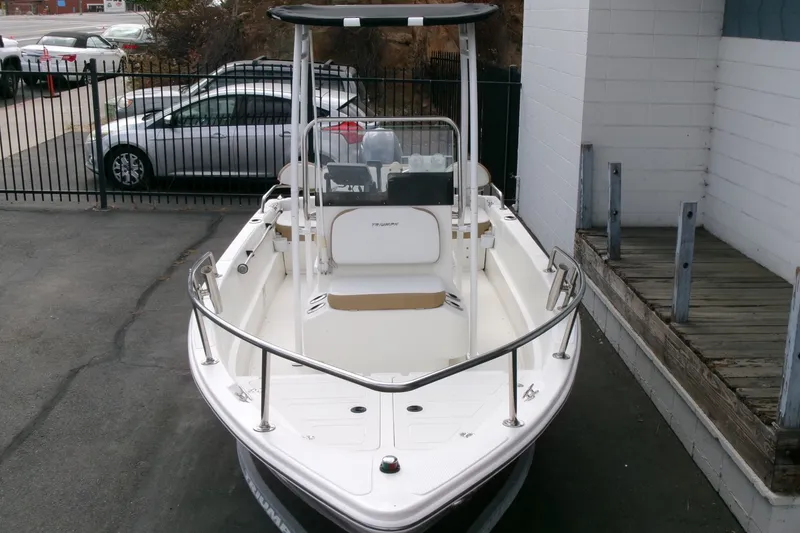 Slide: The Image of 2014 Triumph 170 CC boat with T-top, parked near a fence and building. - 25