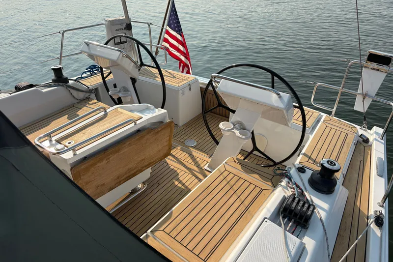 Slide: The Image of 2018 Hanse 455 yacht cockpit with dual steering wheels and American flag. - 6