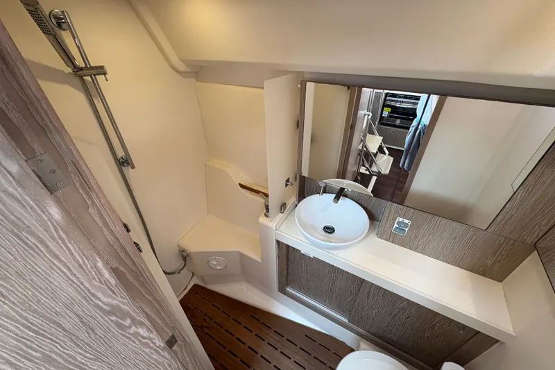 Slide: The Image of 2018 Hanse 455 yacht bathroom with modern sink, shower, and wooden flooring. - 28