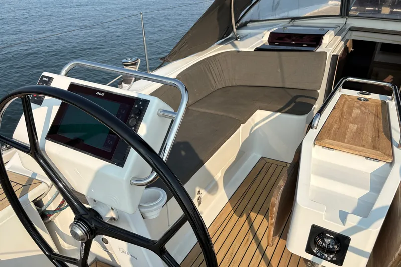 Slide: The Image of 2018 Hanse 455 yacht cockpit with steering wheel, navigation system, and seating area. - 7