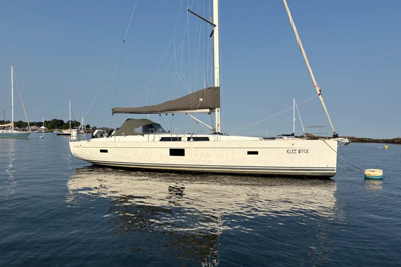The Image of 2018 Hanse 455 sailboat anchored on calm water under clear blue sky. - 0