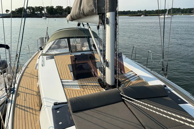 Slide: The Image of 2018 Hanse 455 sailboat with teak deck, anchored in calm waters. - 15