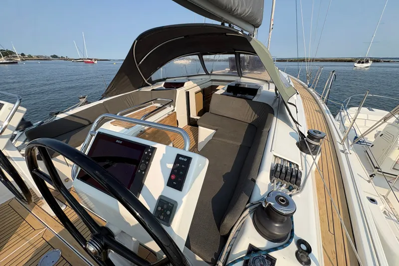Slide: The Image of 2018 Hanse 455 yacht cockpit with navigation equipment, spacious seating, and scenic ocean view. - 10