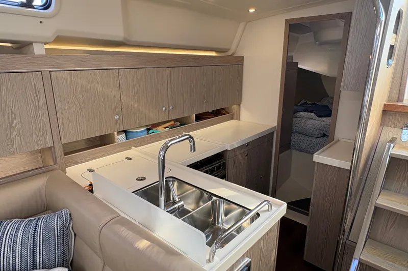 Slide: The Image of Interior of 2018 Hanse 455 yacht featuring modern kitchen with wood cabinetry and stainless steel sink. - 23