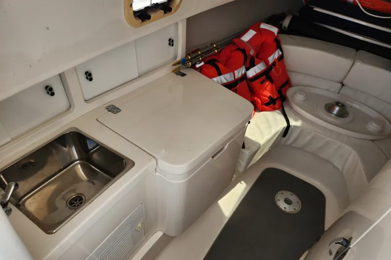Slide: The Image of Interior of 2003 Intrepid 289 Walkaround boat with sink, storage, and life jackets. - 28