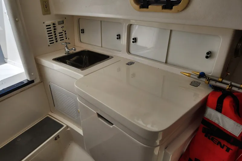 Slide: The Image of 2003 Intrepid 289 Walkaround boat interior with sink and storage compartments. - 32