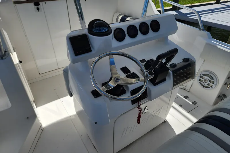 Slide: The Image of 2003 Intrepid 289 Walkaround boat helm with steering wheel and controls. - 13