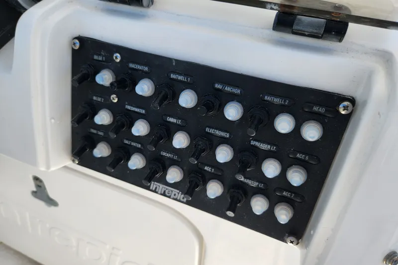Slide: The Image of Control panel of a 2003 Intrepid 289 Walkaround boat with labeled switches. - 15