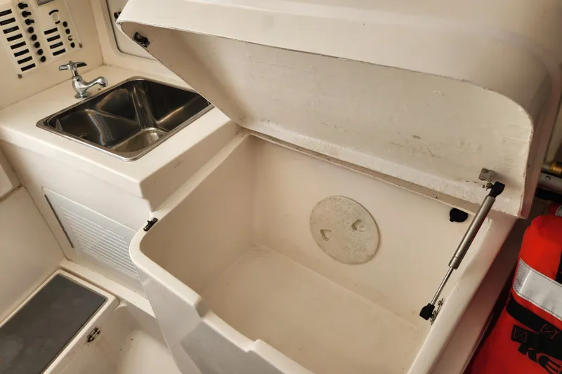 Slide: The Image of 2003 Intrepid 289 Walkaround boat interior with sink and storage compartment. - 34