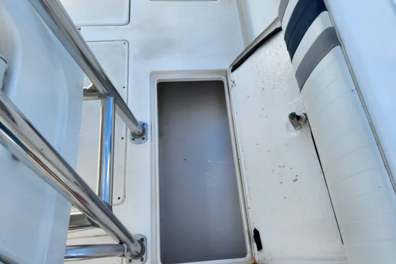 Slide: The Image of An open storage compartment on a boat with white and blue upholstery. - 38