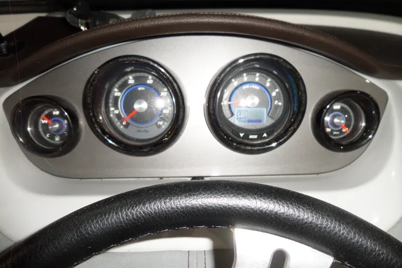 Slide: The Image of Dashboard of a 2017 Sea Ray SDX 240 boat with gauges and steering wheel. - 34