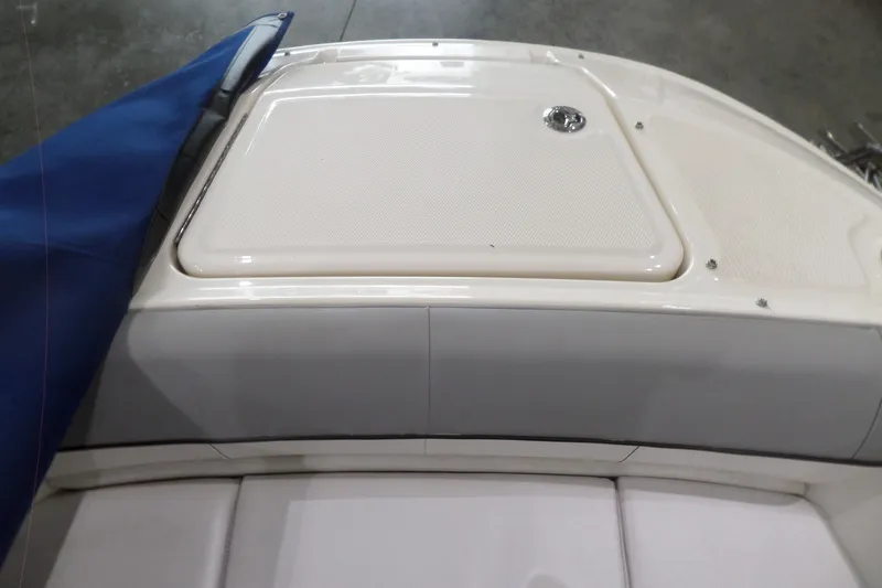 Slide: The Image of 2017 Sea Ray SDX 240 boat deck with blue cover and storage compartment. - 40