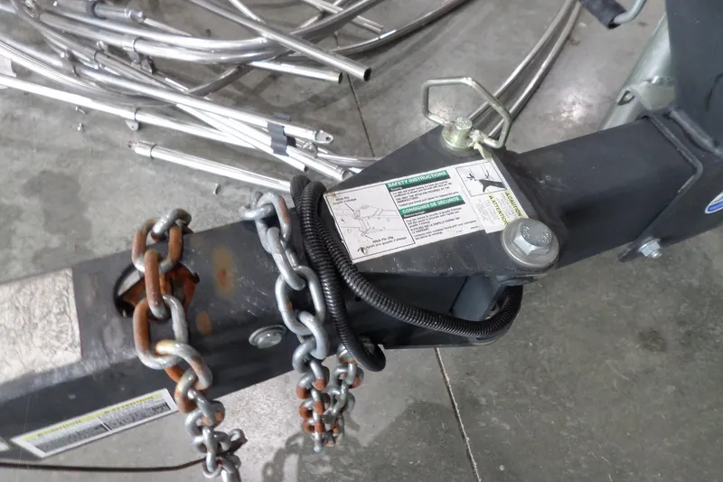 Slide: The Image of Trailer hitch with safety chains and instructions for a 2017 Sea Ray SDX 240 boat. - 59