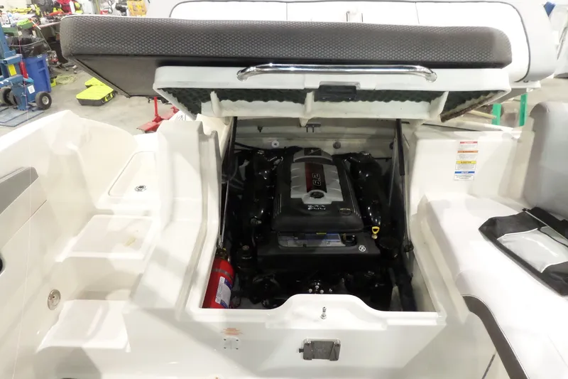 Slide: The Image of 2017 Sea Ray SDX 240 boat engine compartment with open hatch, showcasing engine details. - 54