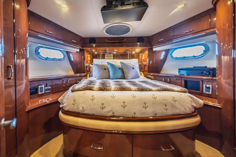 Slide: The Image of Luxurious 2004 Marquis 59 yacht bedroom with elegant wood finishes and cozy bedding. - 59