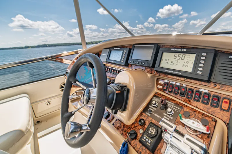 Slide: The Image of Helm of 2004 Marquis 59 yacht with advanced navigation controls and scenic water view. - 27
