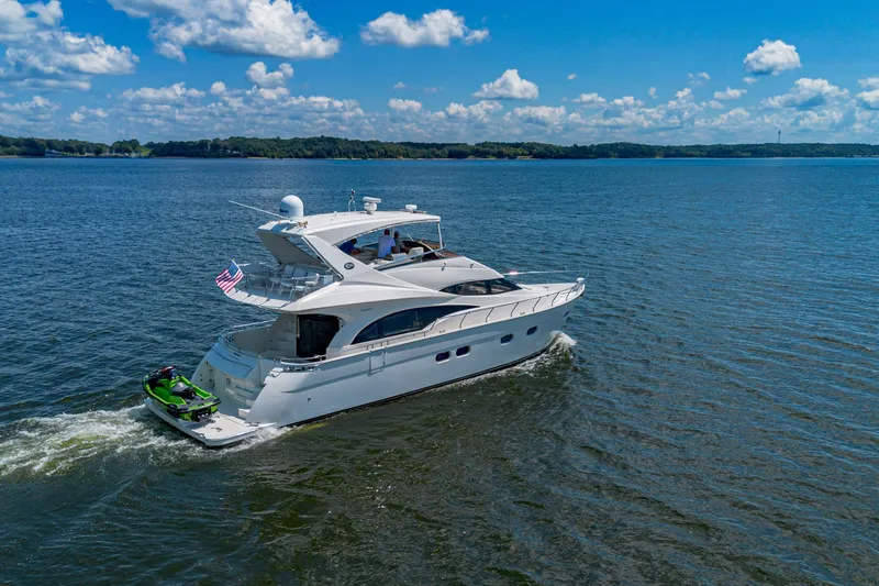 Slide: The Image of Luxury 2004 Marquis 59 yacht cruising on a sunny day with jet ski onboard. - 2