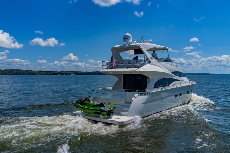 Slide: The Image of Luxurious 2004 Marquis 59 yacht cruising on a sunny day with jet ski onboard. - 4