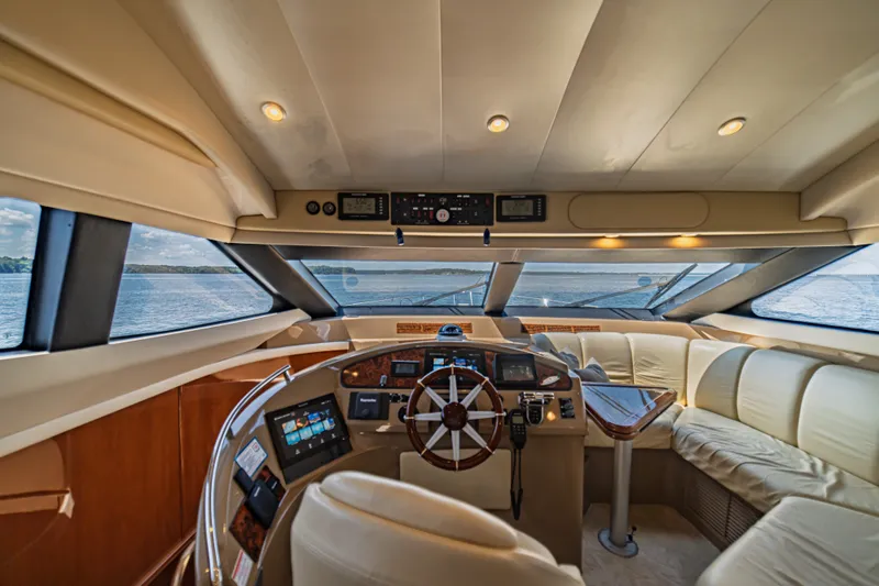 Slide: The Image of Luxurious 2004 Marquis 59 yacht interior with helm, leather seating, and panoramic windows. - 55