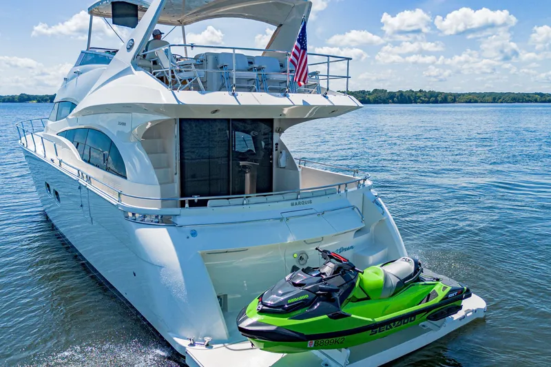 Slide: The Image of Luxury 2004 Marquis 59 yacht with jet ski on calm water, sunny day. - 23