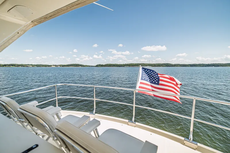 Slide: The Image of Luxury yacht deck with American flag, serene lake view, Marquis 59, 2004 model. - 34