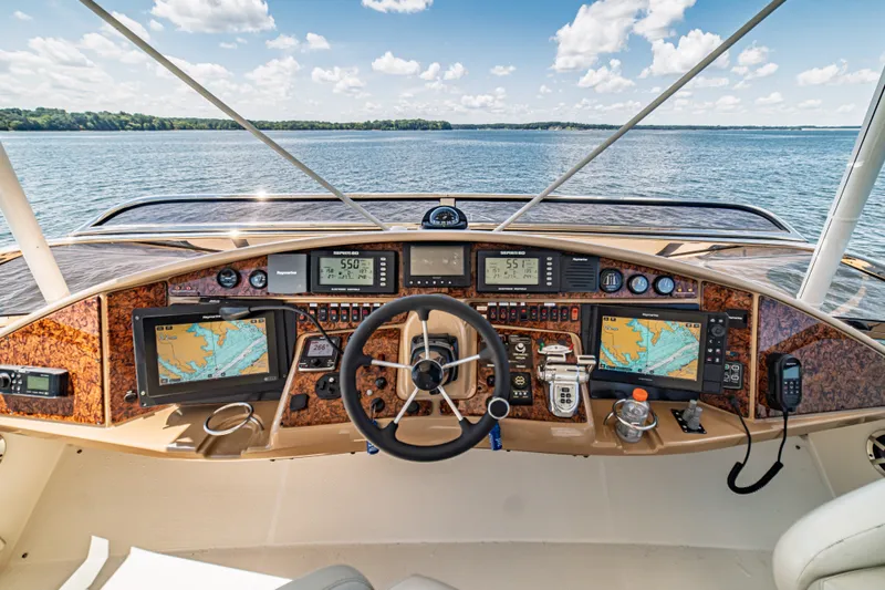 Slide: The Image of Cockpit view of 2004 Marquis 59 yacht with navigation equipment and scenic water backdrop. - 24