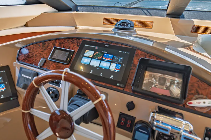Slide: The Image of Helm of 2004 Marquis 59 yacht with advanced navigation displays and controls. - 54