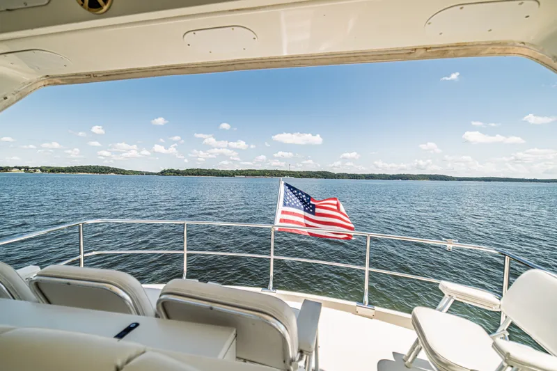 Slide: The Image of Luxury yacht Marquis 59 (2004) with American flag on serene lake. - 31