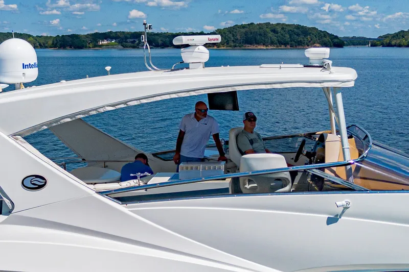 Slide: The Image of 2004 Marquis 59 yacht cruising on a scenic lake with passengers onboard. - 9