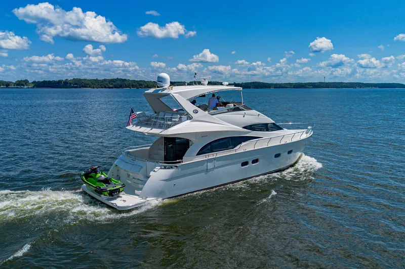 Slide: The Image of Luxurious 2004 Marquis 59 yacht cruising on a sunny day with jet ski attached. - 3