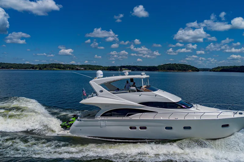 Slide: The Image of Luxurious 2004 Marquis 59 yacht cruising on a serene lake under a clear blue sky. - 10