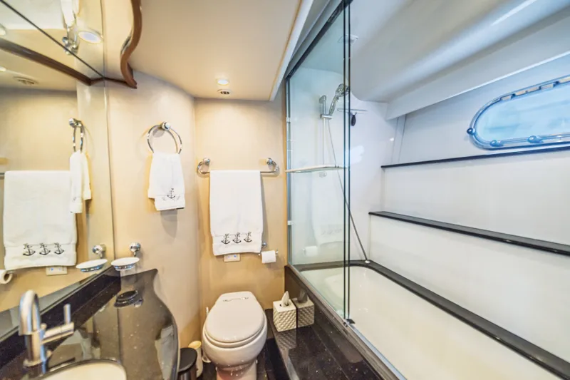 Slide: The Image of Luxurious 2004 Marquis 59 yacht bathroom with glass shower, elegant fixtures, and nautical-themed towels. - 68
