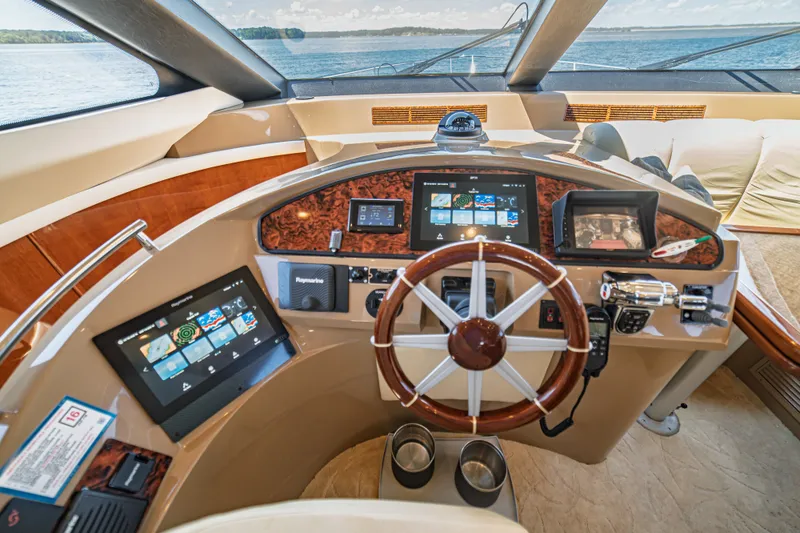 Slide: The Image of Cockpit of 2004 Marquis 59 yacht with modern navigation equipment and wooden steering wheel. - 52