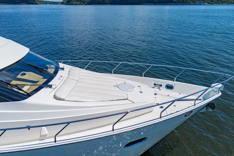 Slide: The Image of 2004 Marquis 59 yacht on serene water, showcasing sleek design and spacious deck. - 19
