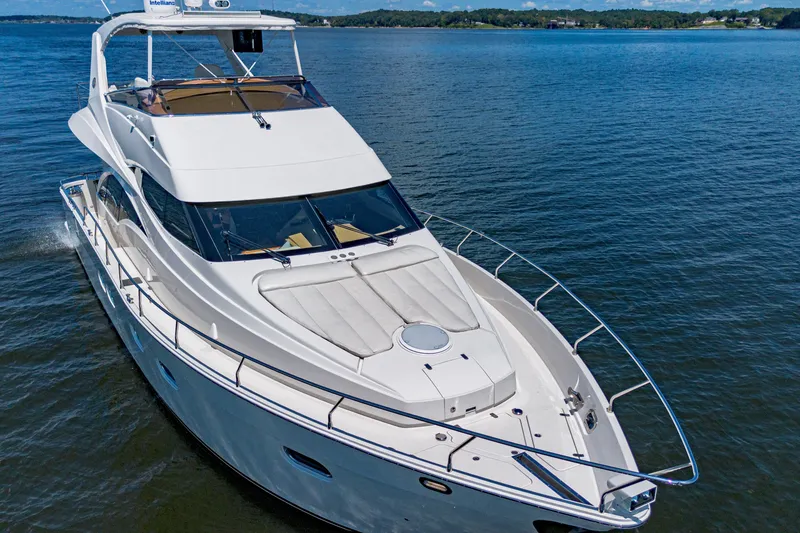 Slide: The Image of Luxury 2004 Marquis 59 yacht cruising on open water, showcasing sleek design and spacious deck. - 21