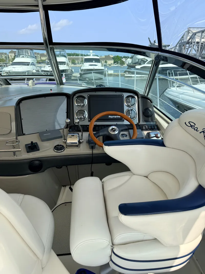 Slide: The Image of The cockpit of a 2005 Sea Ray 420 Sundancer with a sleek steering wheel and modern instruments. - 13