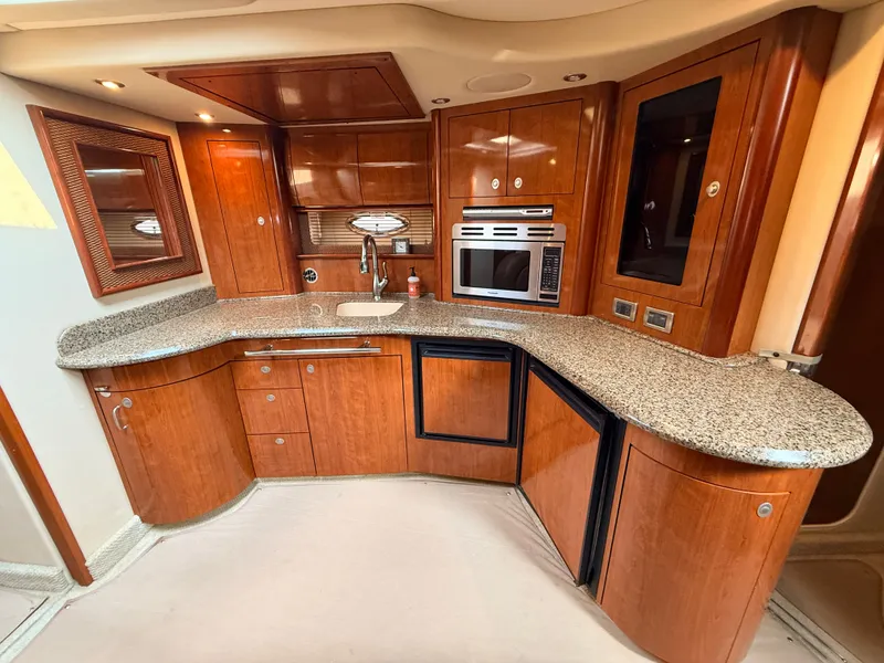 Slide: The Image of The 2005 Sea Ray 420 Sundancer's galley features elegant wood cabinetry and granite countertops. - 18
