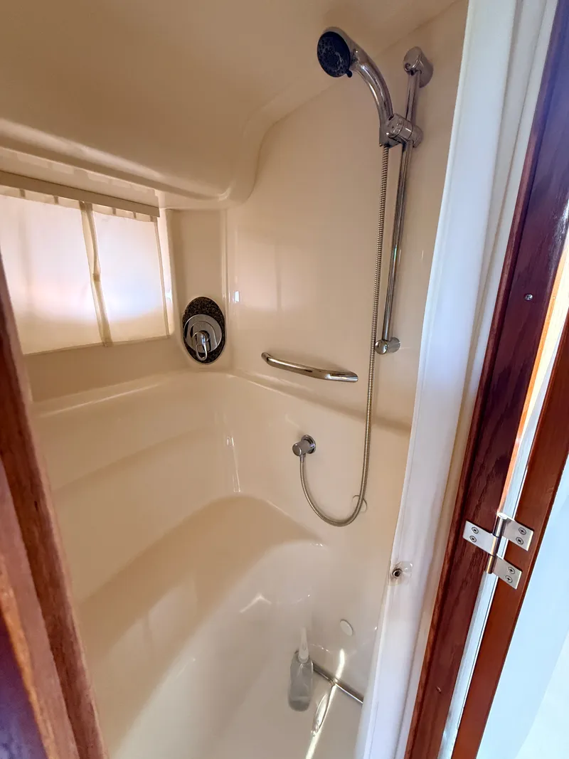 Slide: The Image of The shower cabin of a 2005 Sea Ray 420 Sundancer with a handheld showerhead and grab bar. - 26