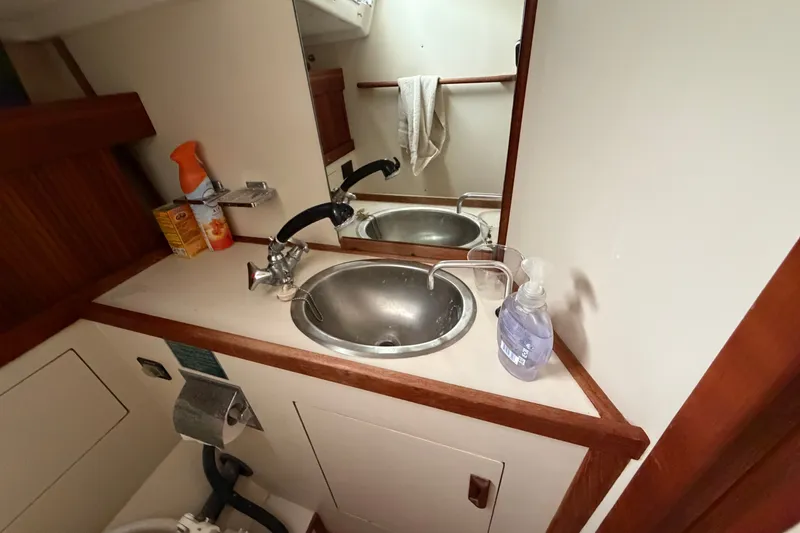 Slide: The Image of Bathroom sink area in a 1990 Sabre 34 MK II yacht, featuring a mirror and toiletries. - 61