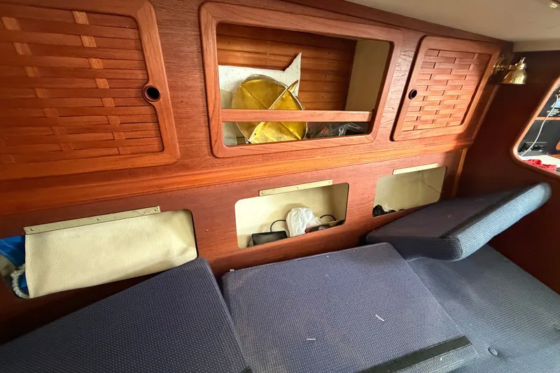 Slide: The Image of Interior of a 1990 Sabre 34 MK II sailboat with wooden cabinetry and blue cushions. - 59