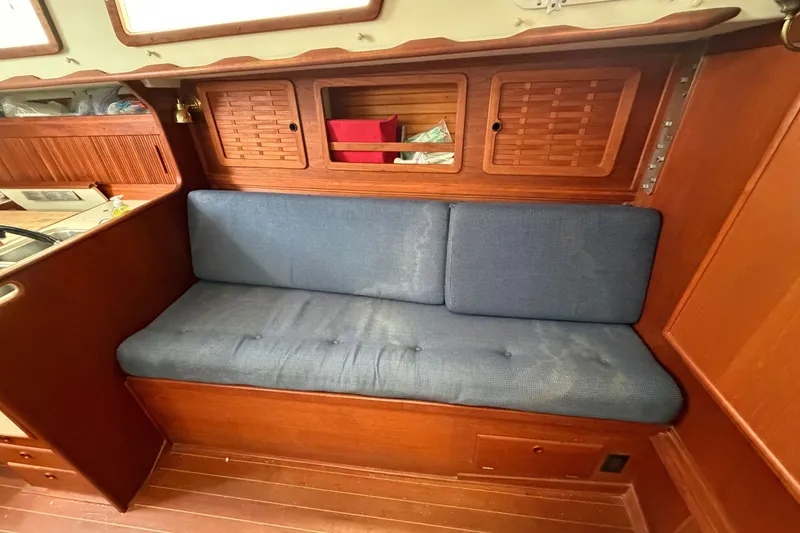 Slide: The Image of Interior of 1990 Sabre 34 MK II sailboat with blue cushioned seating and wooden cabinetry. - 45