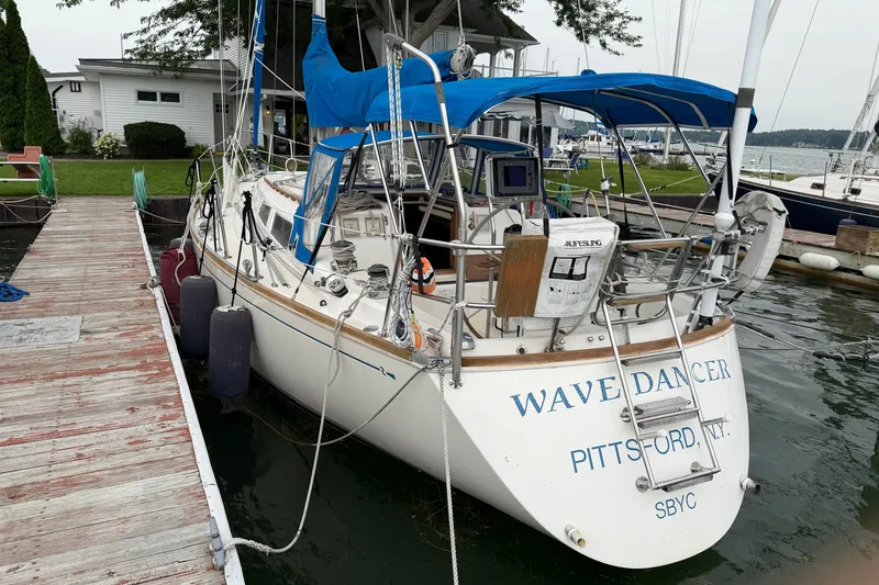 Slide: The Image of 1990 Sabre 34 MK II sailboat docked, featuring blue canopy and "Wave Dancer" name. - 13