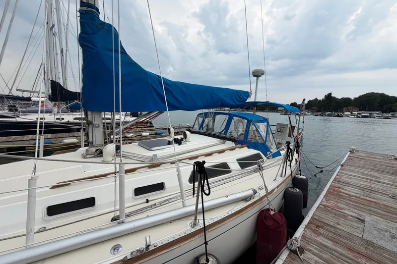 Slide: The Image of 1990 Sabre 34 MK II sailboat docked at a marina under cloudy skies. - 10