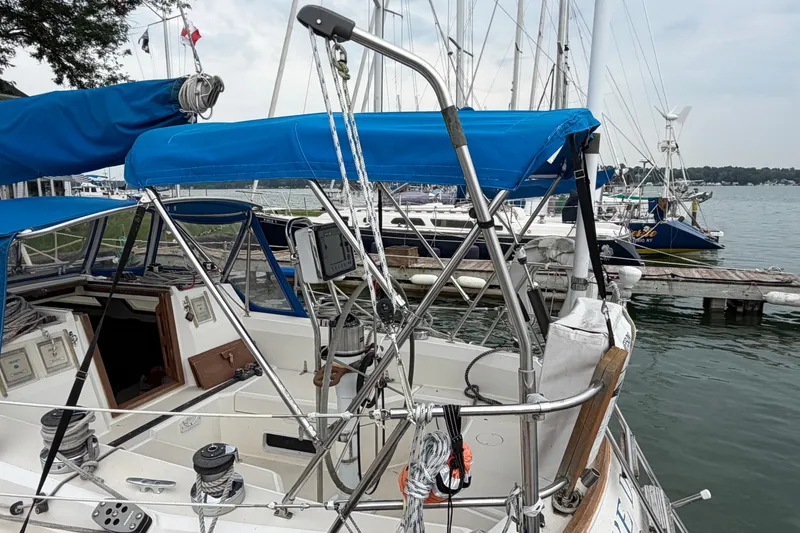 Slide: The Image of 1990 Sabre 34 MK II sailboat docked, featuring blue canopy and nautical equipment. - 15