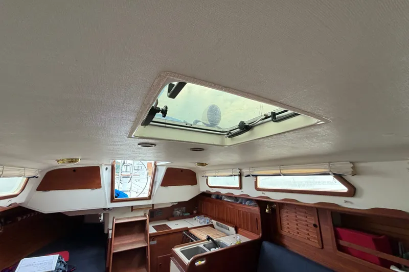 Slide: The Image of Interior of a 1990 Sabre 34 MK II sailboat, featuring a skylight and wooden cabinetry. - 28