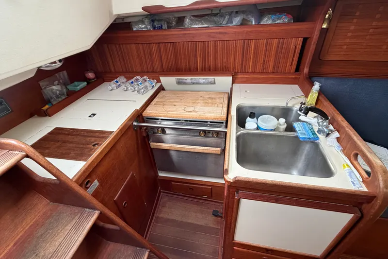 Slide: The Image of 1990 Sabre 34 MK II yacht galley with stove, sink, and wooden cabinetry. - 30