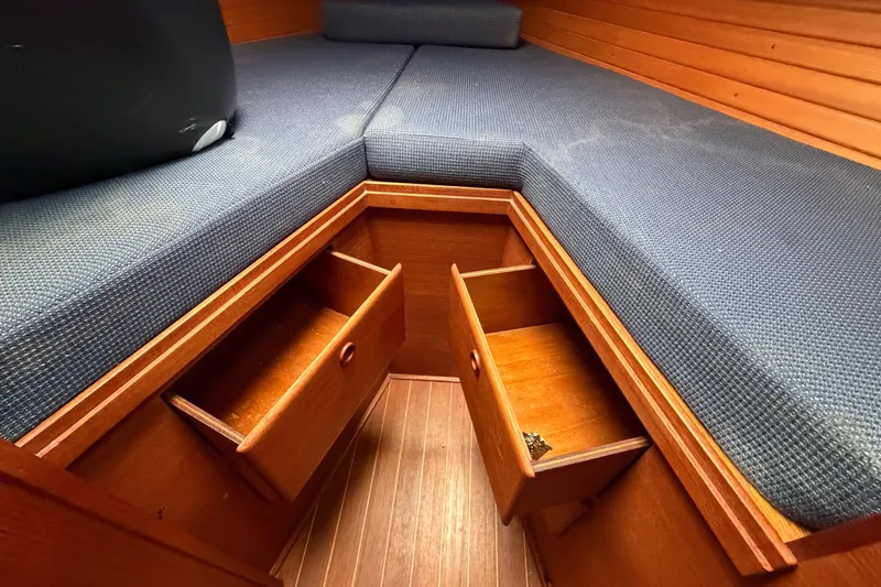 Slide: The Image of Interior of 1990 Sabre 34 MK II sailboat with blue cushions and wooden storage drawers. - 57