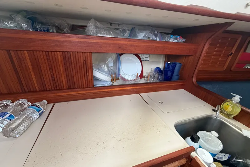 Slide: The Image of Interior of 1990 Sabre 34 MK II sailboat kitchen with wooden cabinets and sink. - 34